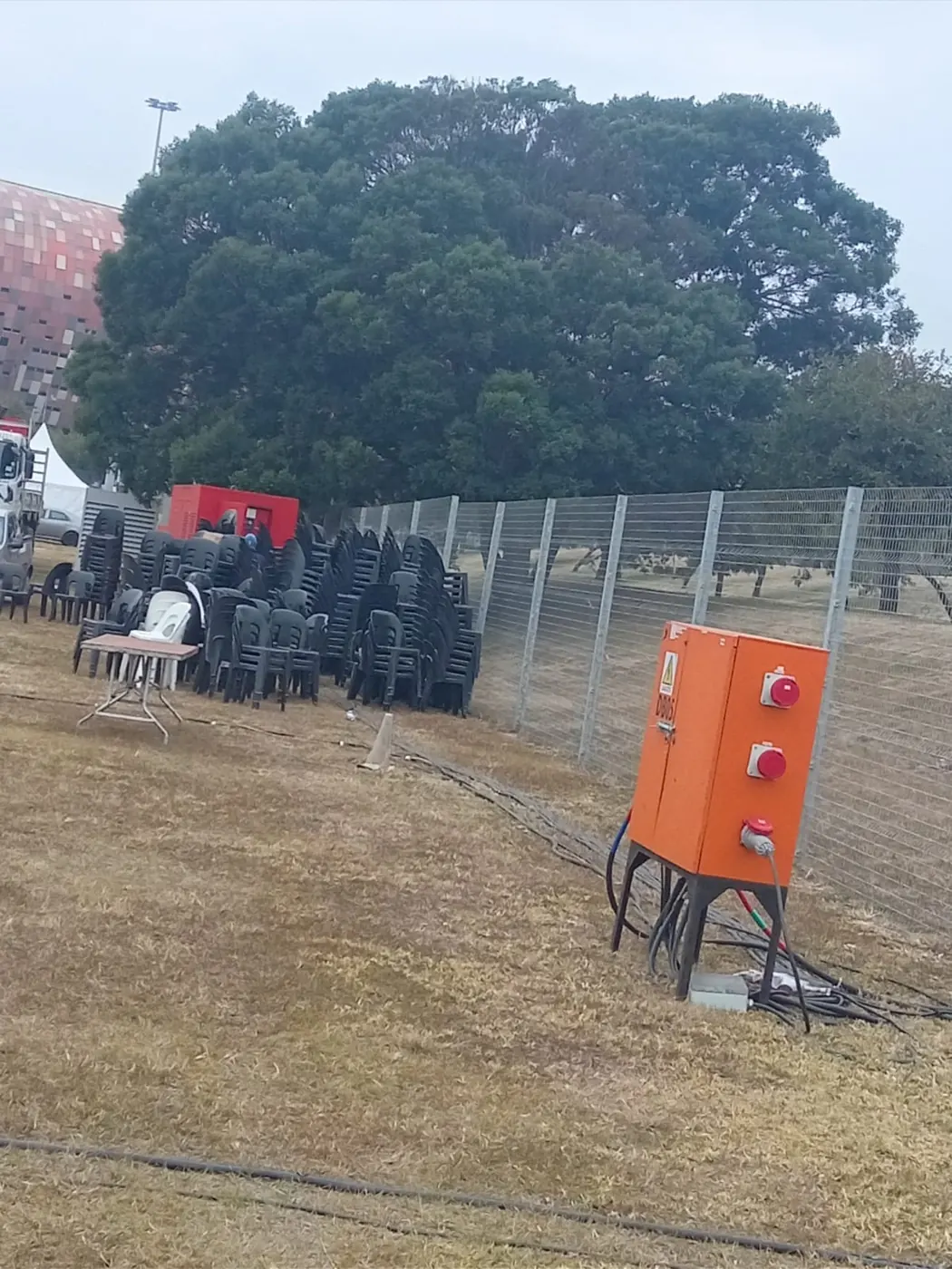 Outdoor power distribution cabinet beside a fenced site